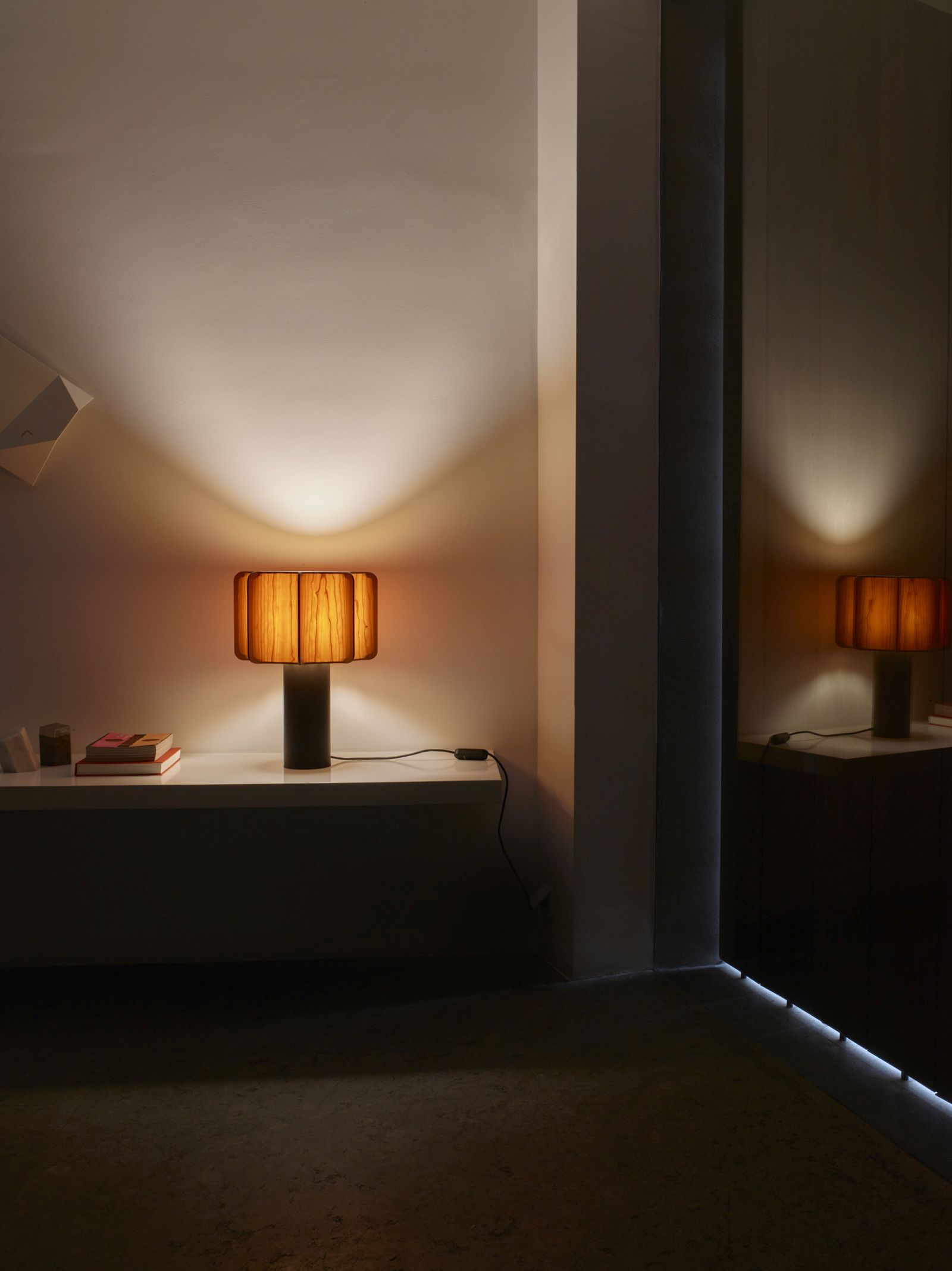 Kactos Tischleuchte von LZF Lamps mit Holzfurnier-Schirm auf einem Regal.