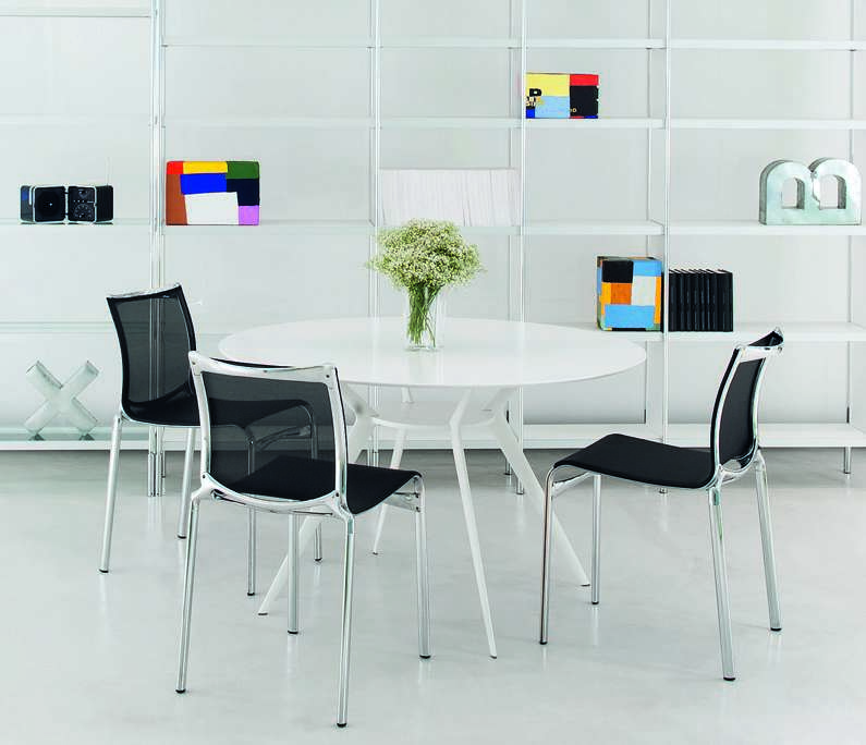 Weißer runder Biplane Tisch von Alias mit vier schwarzen Stühlen in minimalistischem Interieur.