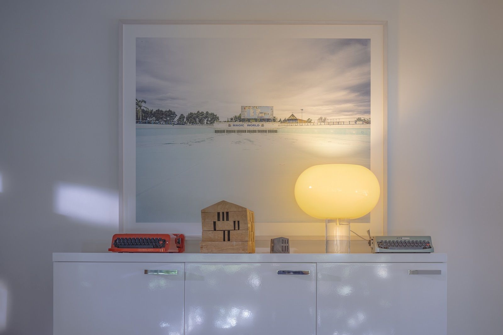 Nahaufnahme der leuchtenden Foscarini Buds 2 Tischleuchte in Cipria auf einem Sideboard.