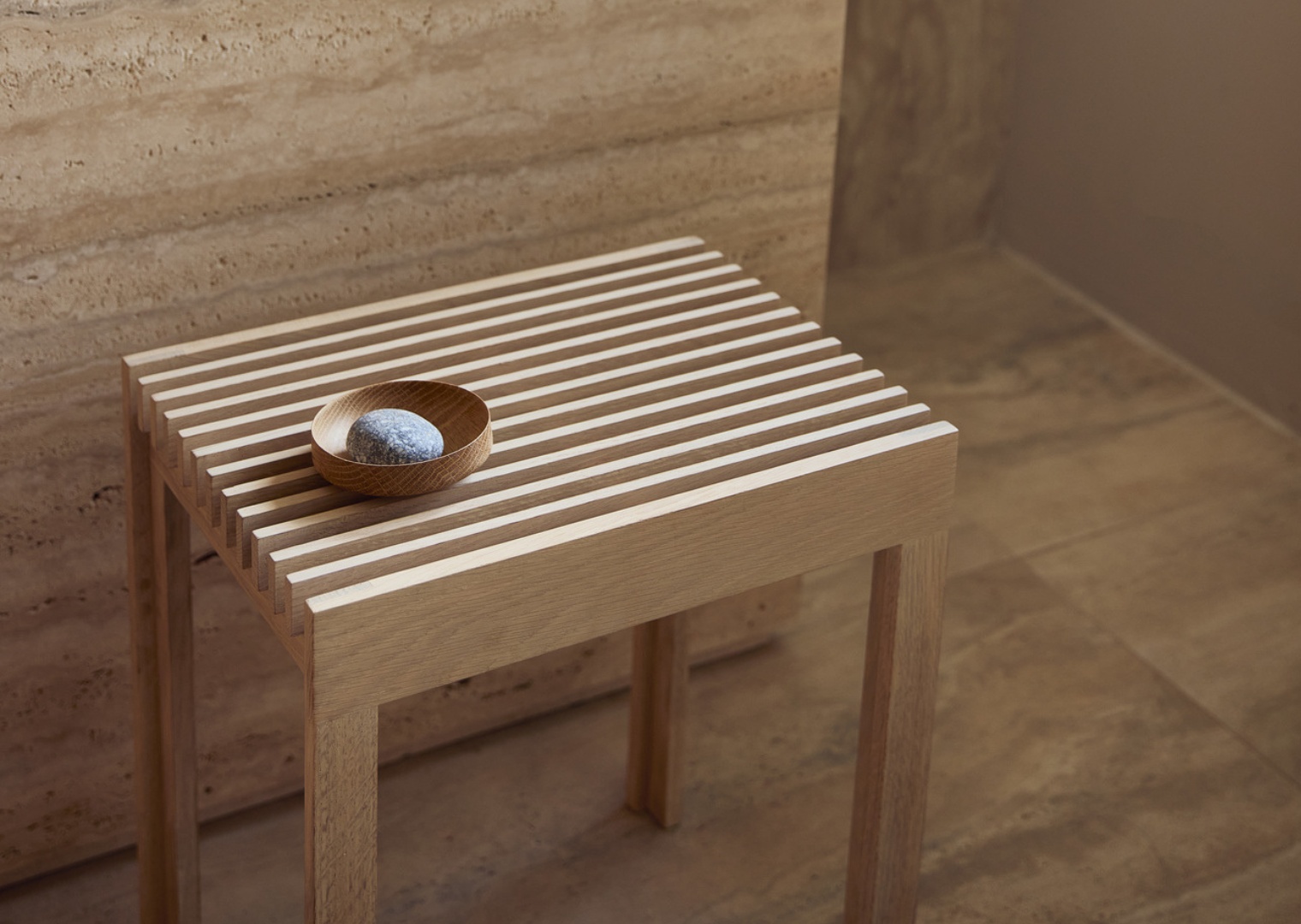 Moderner Holz Hocker für Badezimmer mit Ablage und Dekoschale mit Stein.