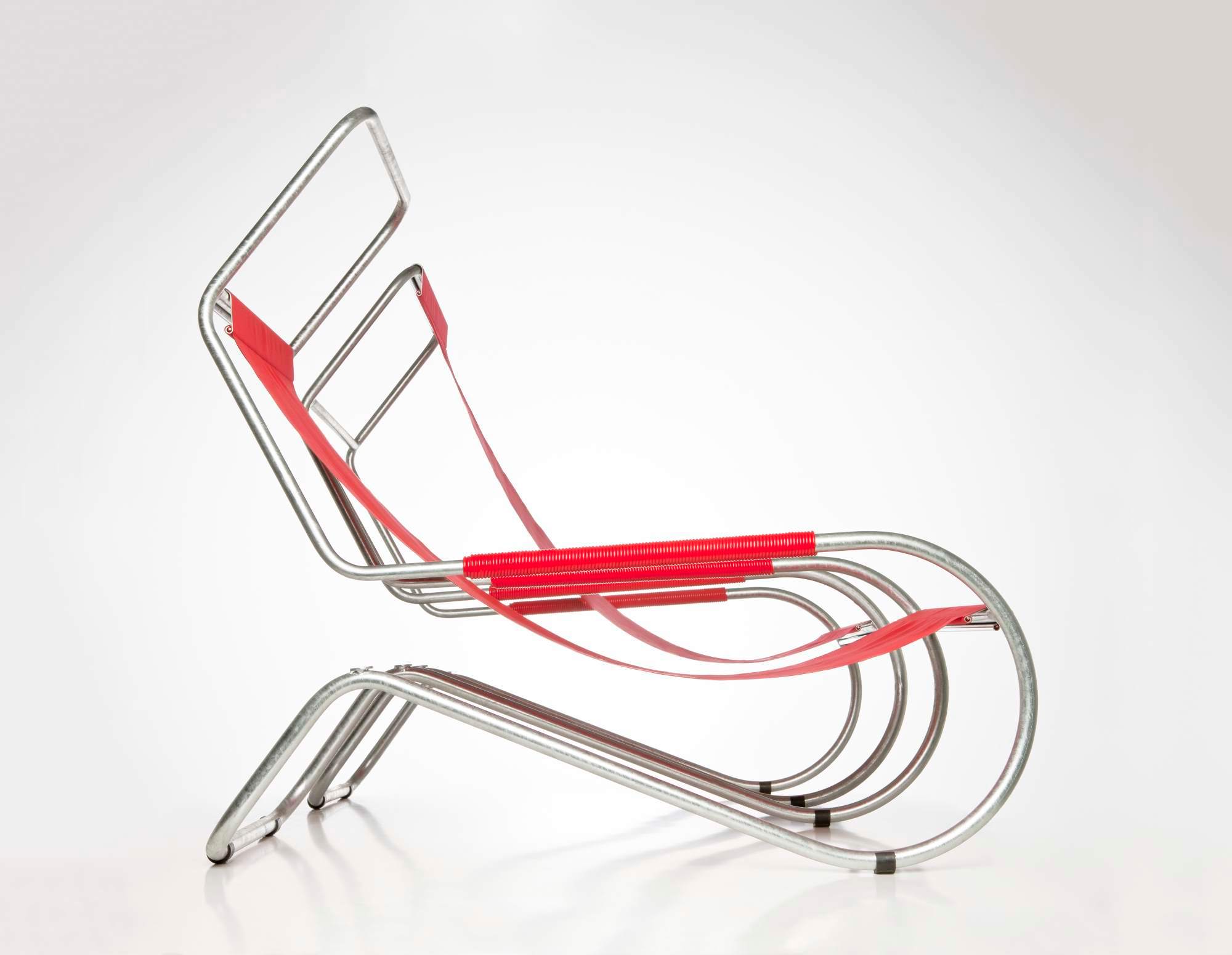 Lido Liege: Moderne Liege mit Stahlrohrgestell und roten Textilbändern, seitliche Ansicht. Designermöbel für Wohnzimmer.