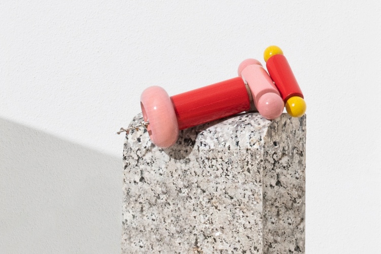 Alessi Korkenzieher ES17 in Rot, Gelb und Rosa auf einem Steinsockel. Design Korkenzieher.