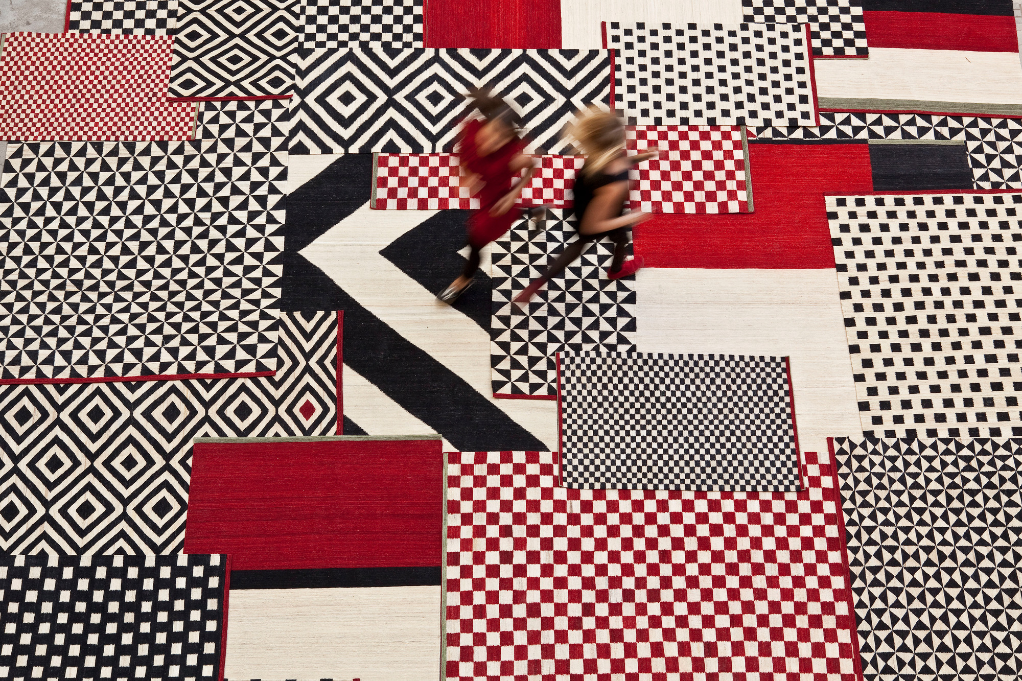 Ansicht von oben: Nanimarquina Mélange Teppich mit geometrischen Mustern in Rot, Schwarz und Weiß.