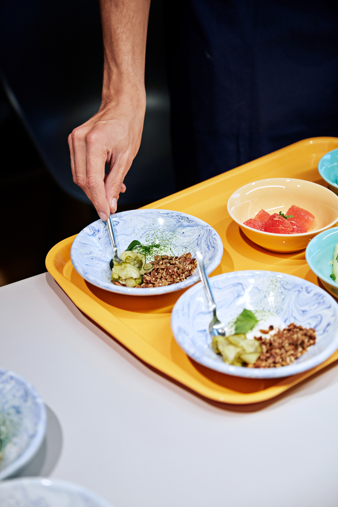 Nahaufnahme von Speisen in Hay Soft Ice Tellern auf einem gelben Tablett. Geschirr für Eis und Desserts.