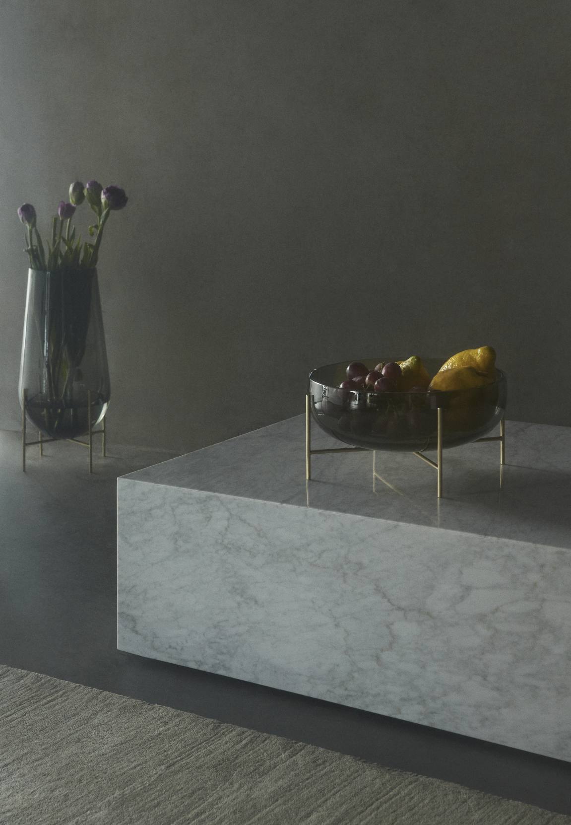 Échasse Bowl Schale von Audo: Glas Obstschale mit goldenem Gestell auf Marmortisch, moderne Dekoration.