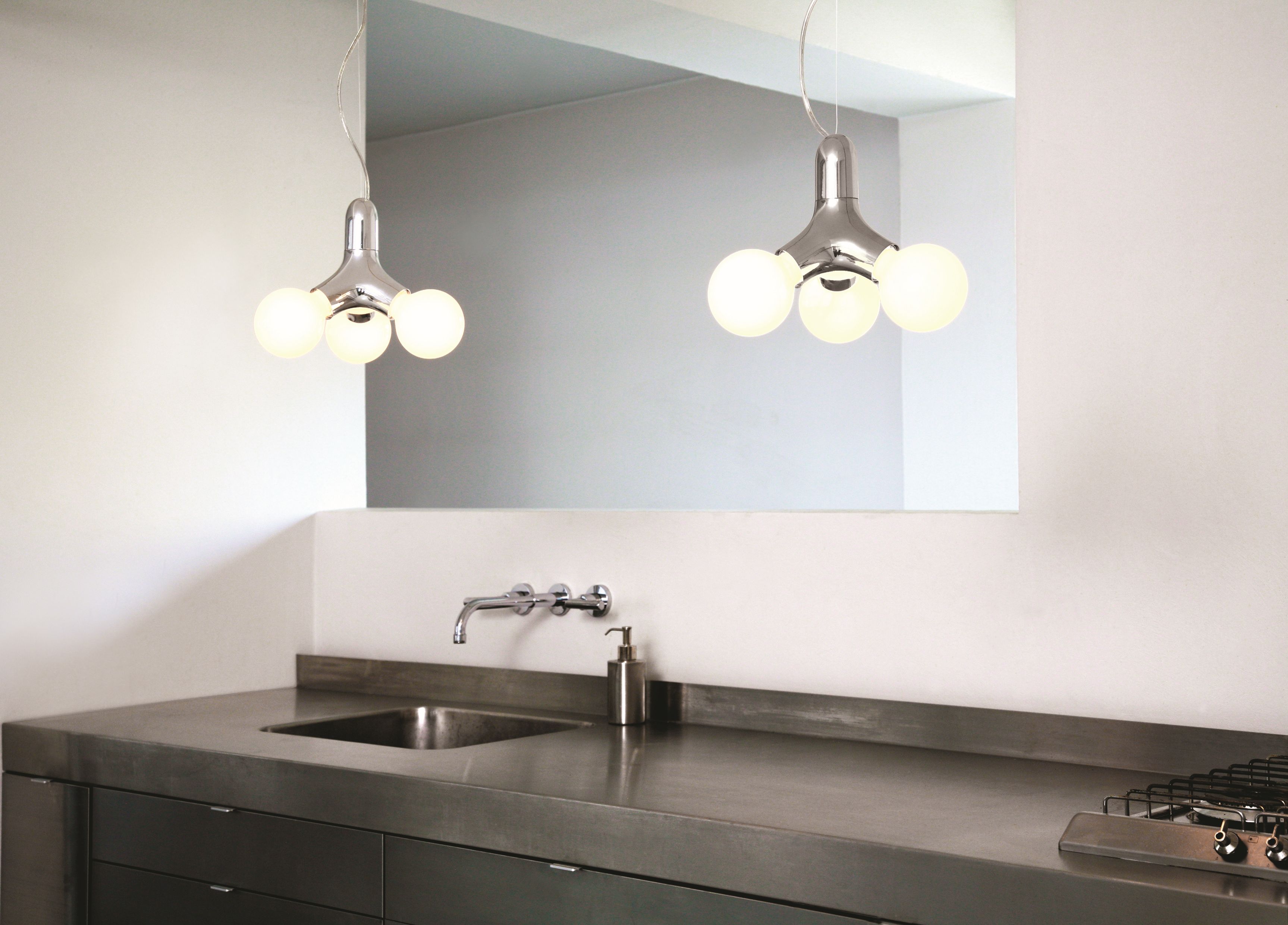 Zwei moderne DNA Pendelleuchten mit drei Kugeln in Kupfer über einer Küchenzeile.