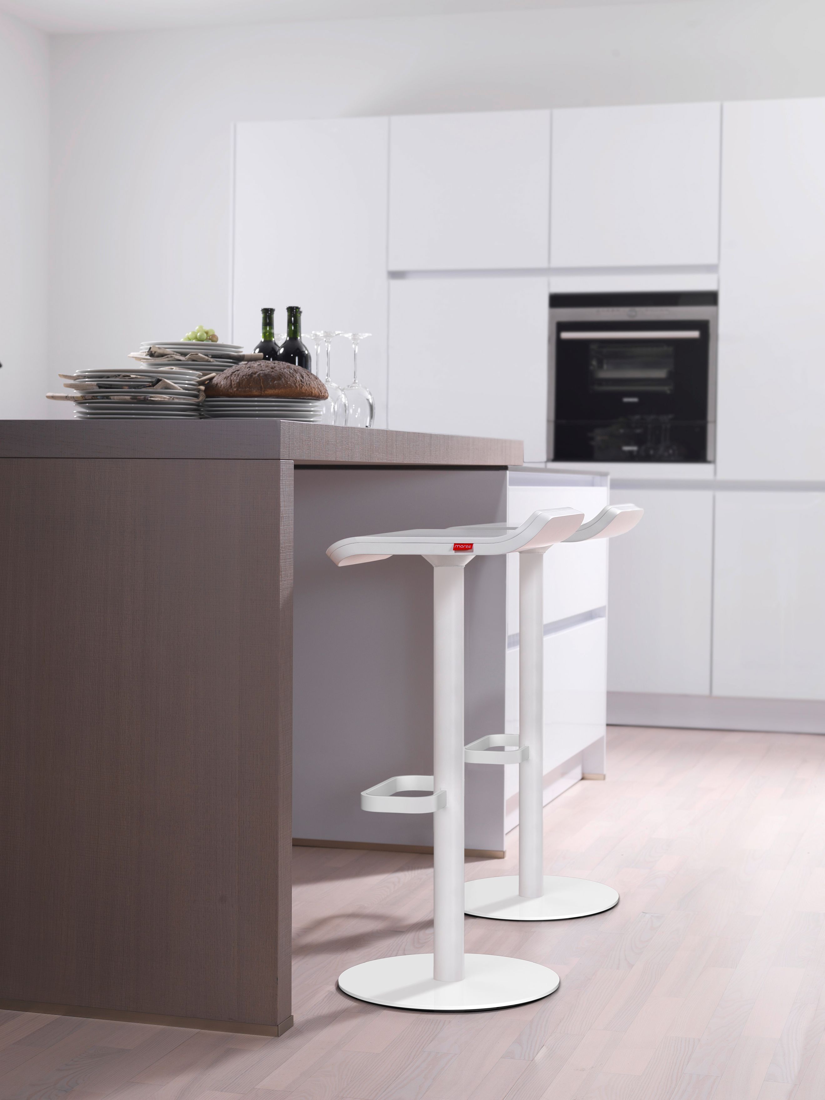 Zwei weiße Moree Barhocker mit Fußstütze vor einer modernen Küchenzeile. Barstuhl für die Küche.