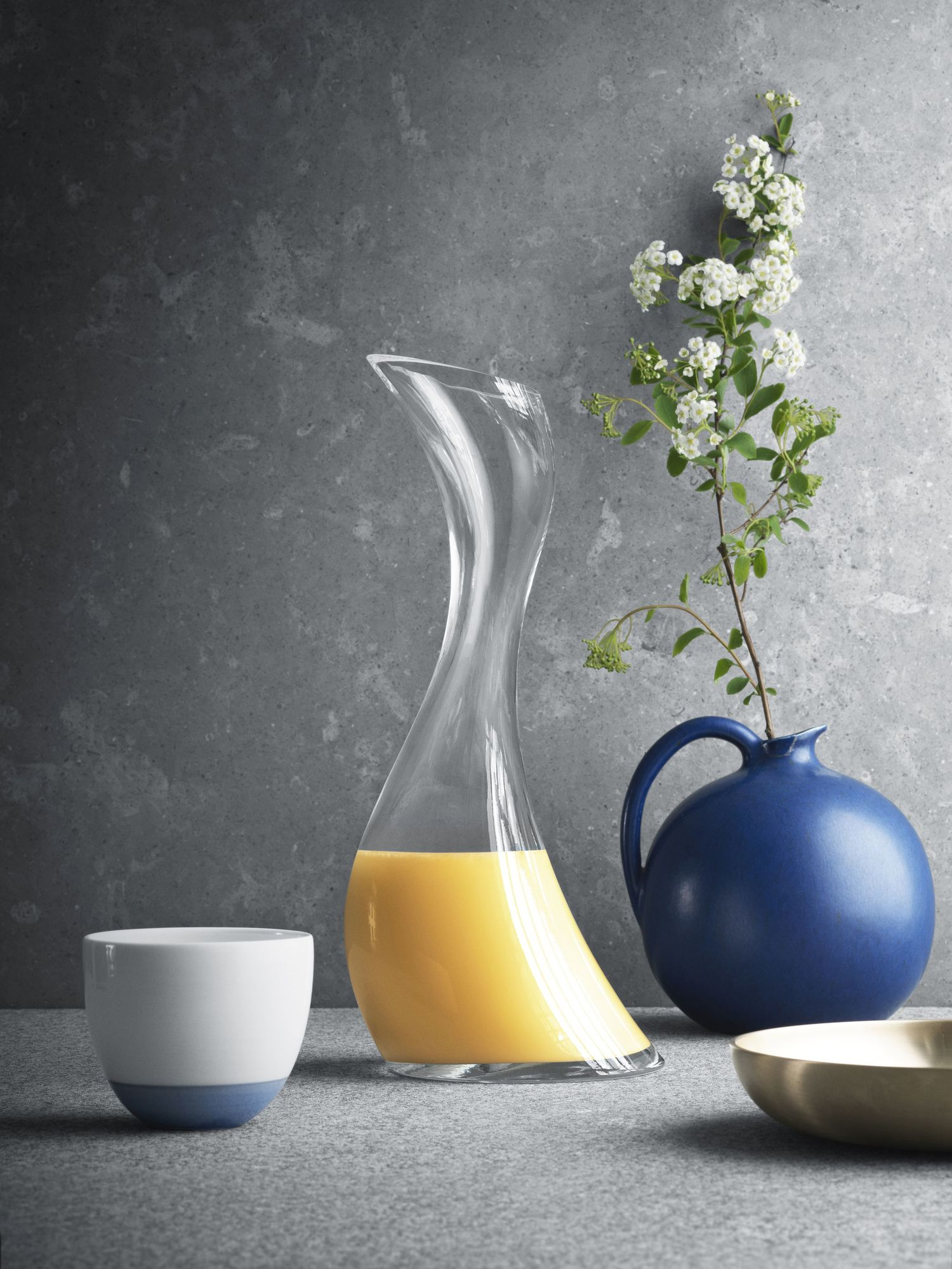 Elegante Cobra Karaffe von Georg Jensen, Klarglas, mit Saft gefüllt, stilvolle Tischdekoration.