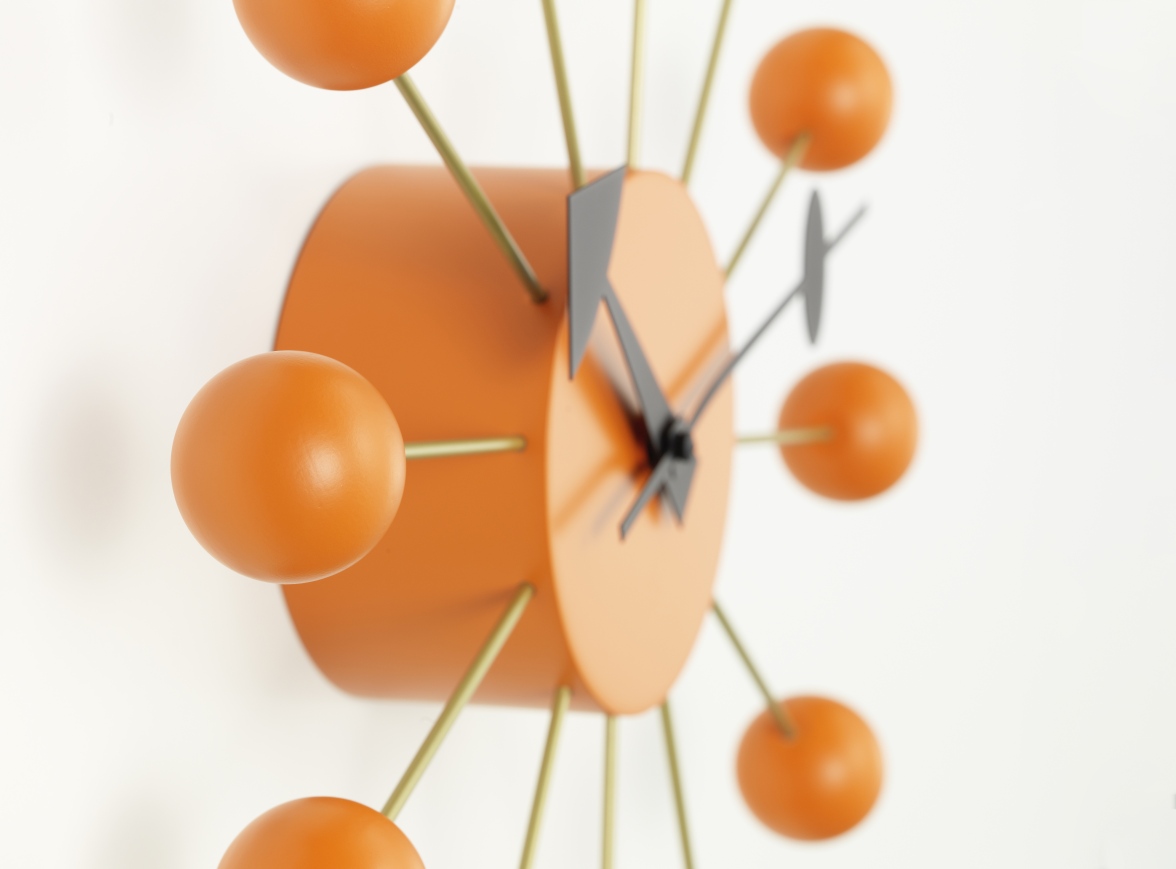 Detailansicht der orangefarbenen Ball Clock Wanduhr von Vitra, modernes Design für Wohnzimmer und Büro.