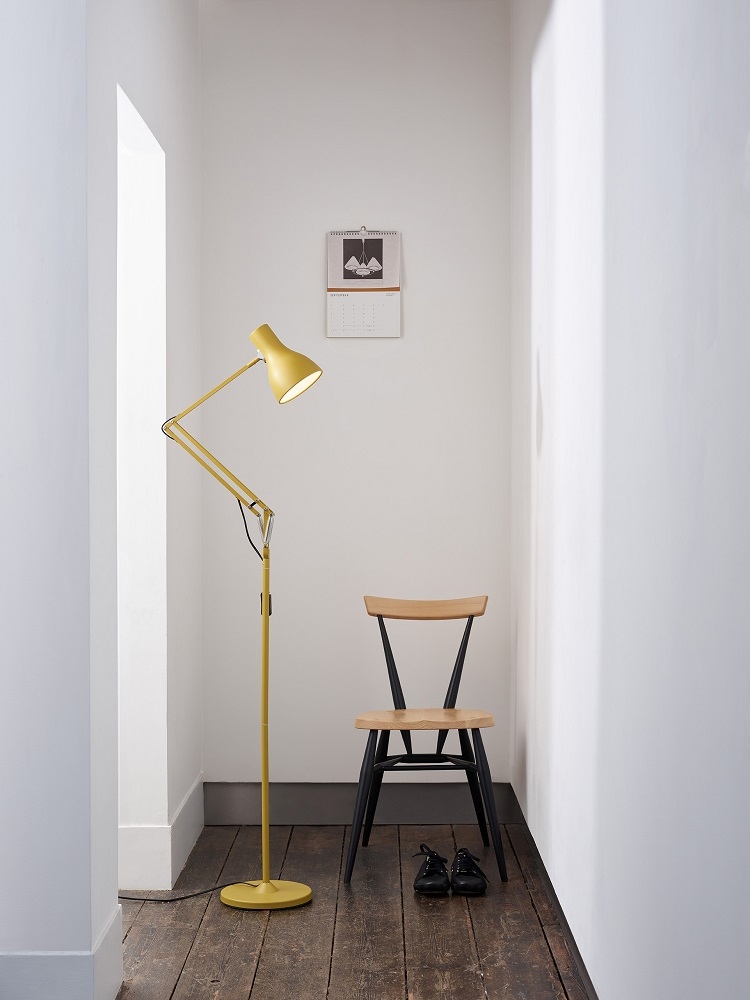 Anglepoise Type 75 Stehleuchte Margaret Howell Edition in Sienna Gelb neben einem Holzstuhl.