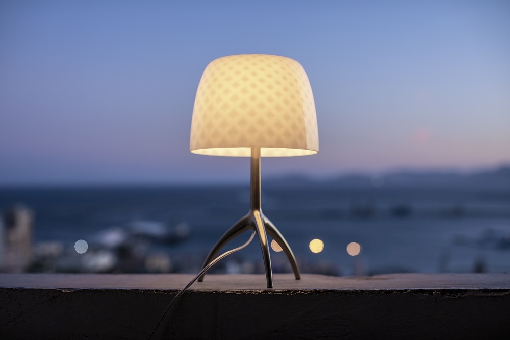 Lumiere Tischleuchte von Foscarini: Elegante Nachttischlampe mit gemustertem Schirm und filigranem Metallfuß.