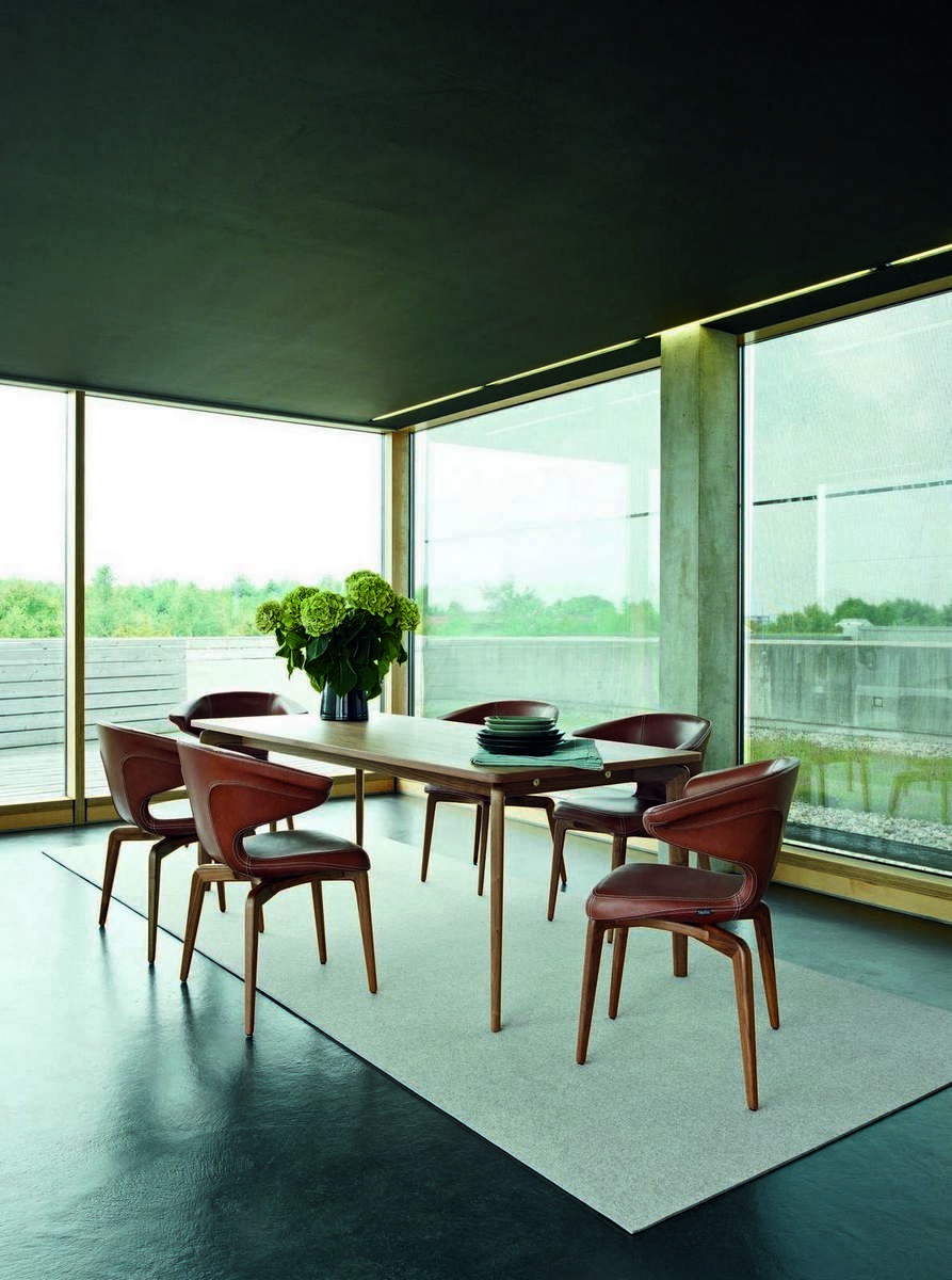 Esszimmer mit ClassiCon Munich Armchair Stühlen aus Leder und Holztisch.