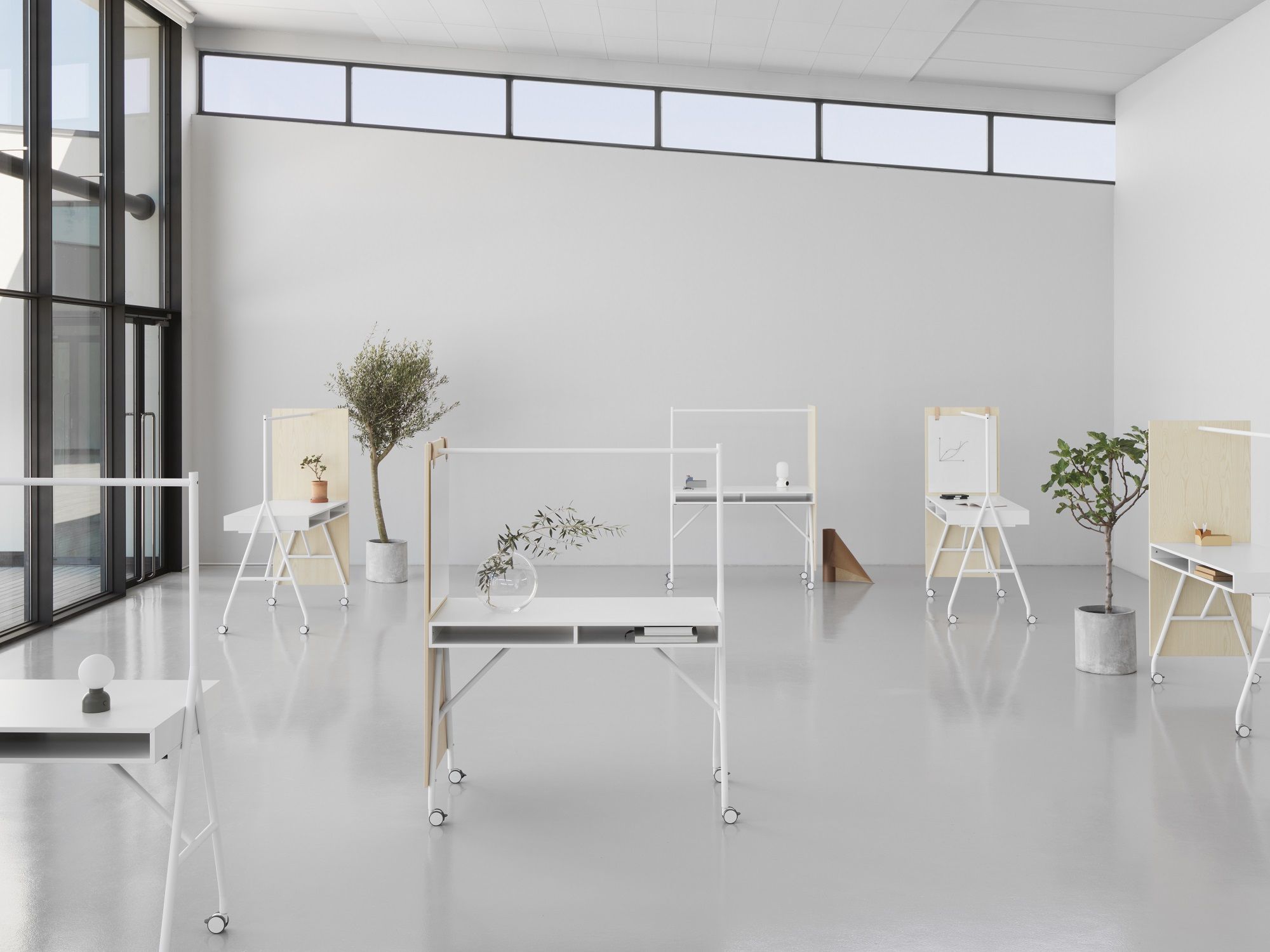 Helle Büroumgebung mit mehreren weißen Hangout Stehtischen von Mizetto mit Rollen.