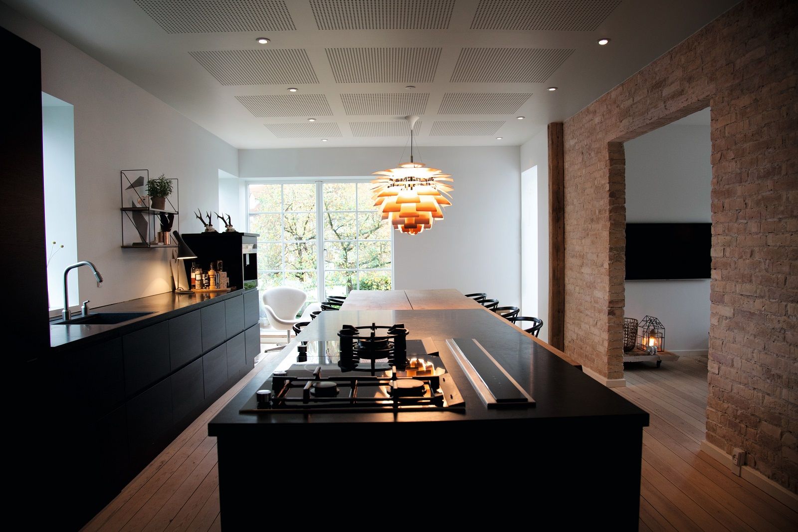 Moderne Küche mit Louis Poulsen PH Artichoke Pendelleuchte als Design-Highlight über dem Esstisch.