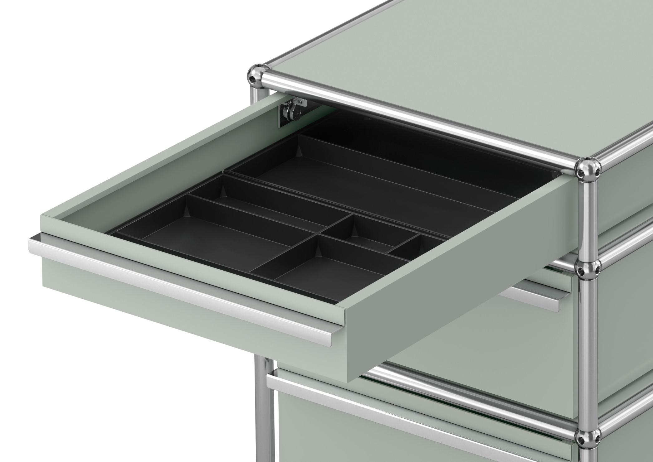 Detailaufnahme USM Haller Rollcontainer mit drei Schubladen in Lichtgrau, eine Schublade ist geöffnet.