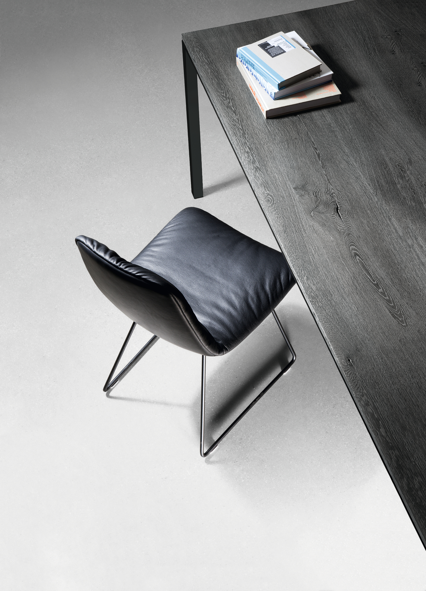 Detailaufnahme: Janua S 600 Tisch Eiche geölt mit Stuhl und Büchern, modernes Möbeldesign.