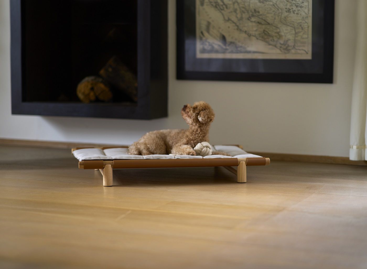 Brauner Pudel liegt entspannt auf Berberé Hundebett mit Kissenbezug von Opinion Ciatti.