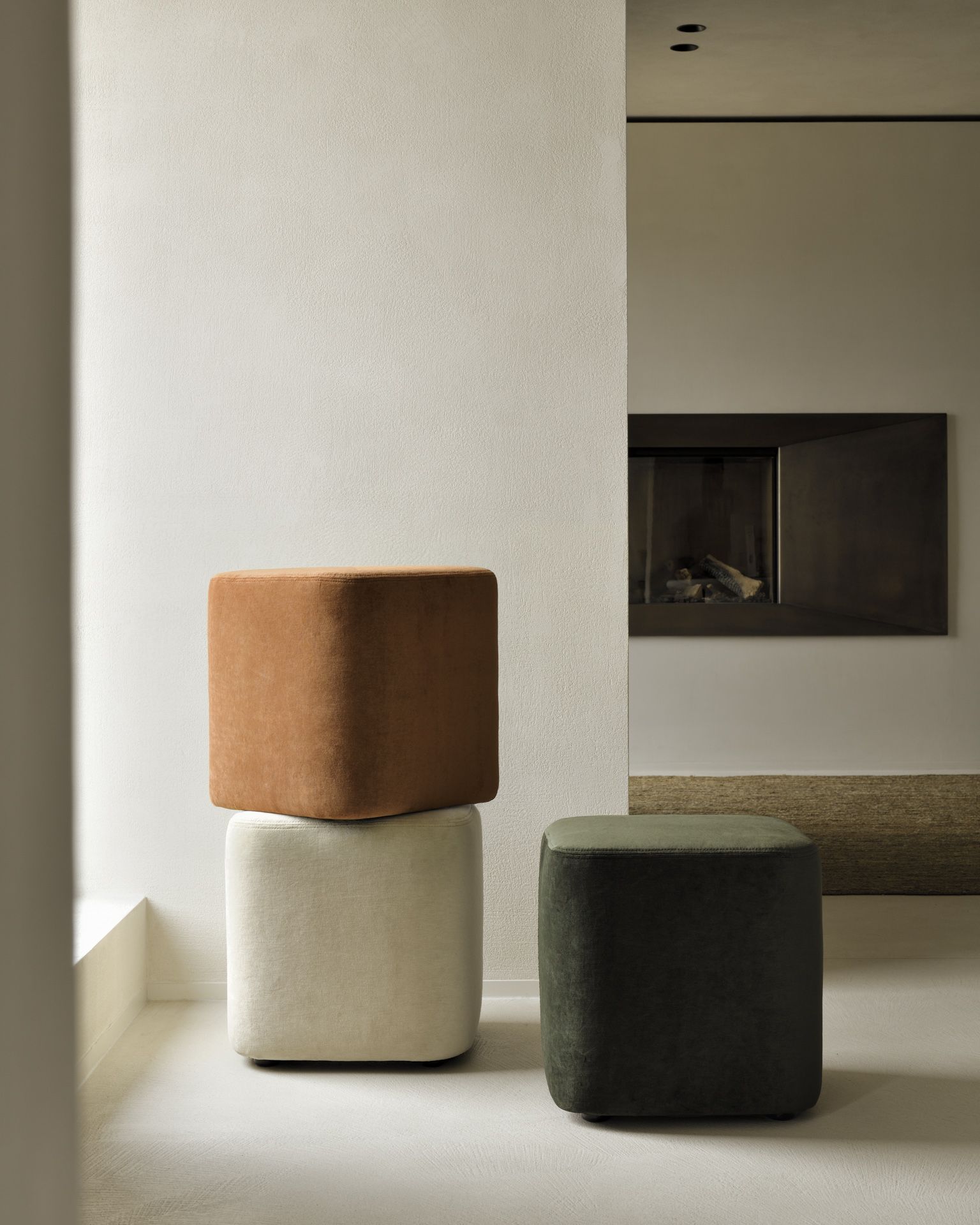 Cube Pouf Sitzhocker von Ethnicraft: Stapel aus braunen, weißen und grünen Sitzhockern im Wohnzimmer.