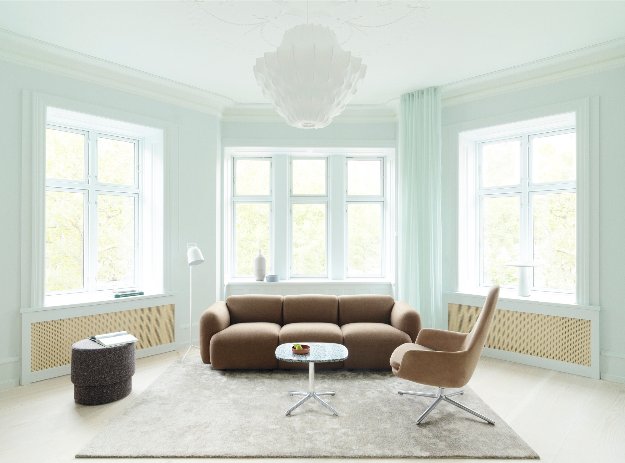 Helle Wohnung mit großer, weißer Phantom Pendelleuchte von Normann Copenhagen als Deckenleuchte.