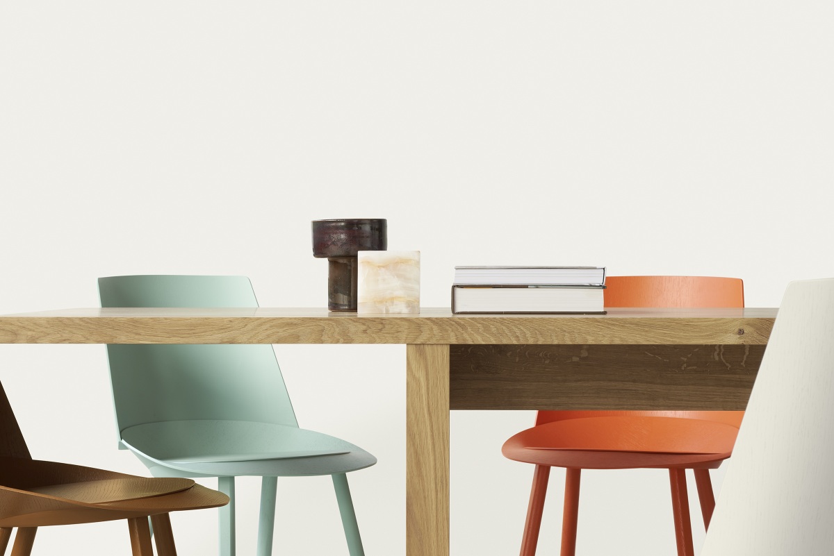 Detailaufnahme des e15 DC09 Galerie Tisches aus Holz mit Stühlen und Dekoration.