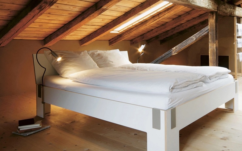 Modernes Bett mit Kopfteil, stilvolles Design von Nils Holger Moormann, gemütliche Atmosphäre.