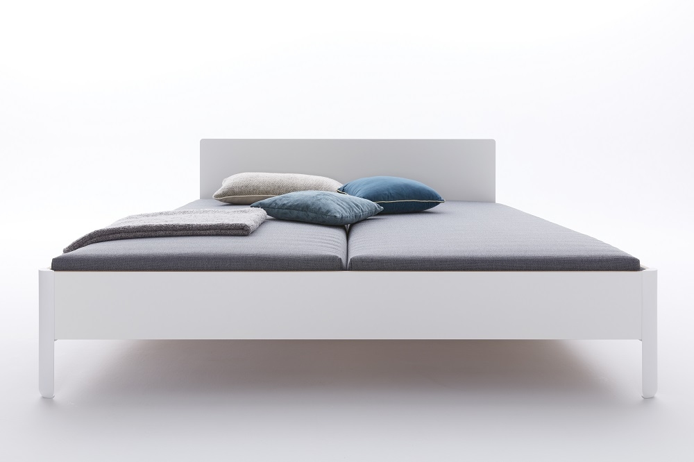 Weißes Nait Bett von Müller Möbelwerkstätten mit grauer Matratze und Kissen. Modernes Design.