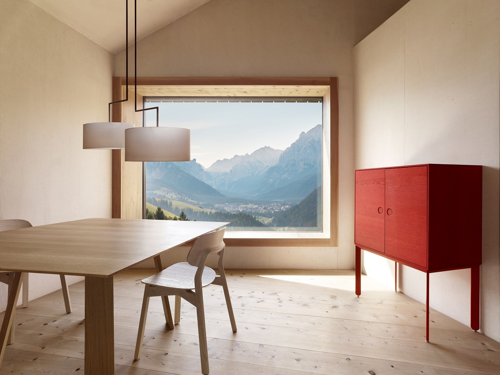 BONDT Tisch rechteckig aus Holz im Esszimmer mit Bergblick und rotem Schrank.