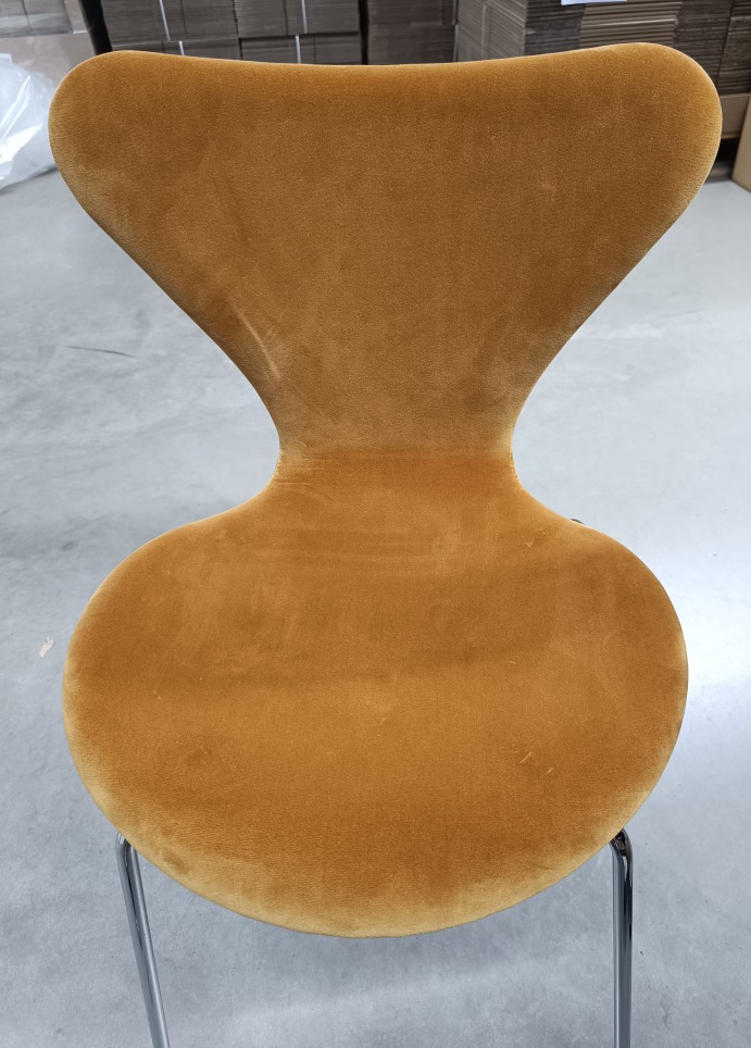 Nahaufnahme des Series 7 Stuhls von Fritz Hansen, vollgepolstert mit Samt in Ocker.