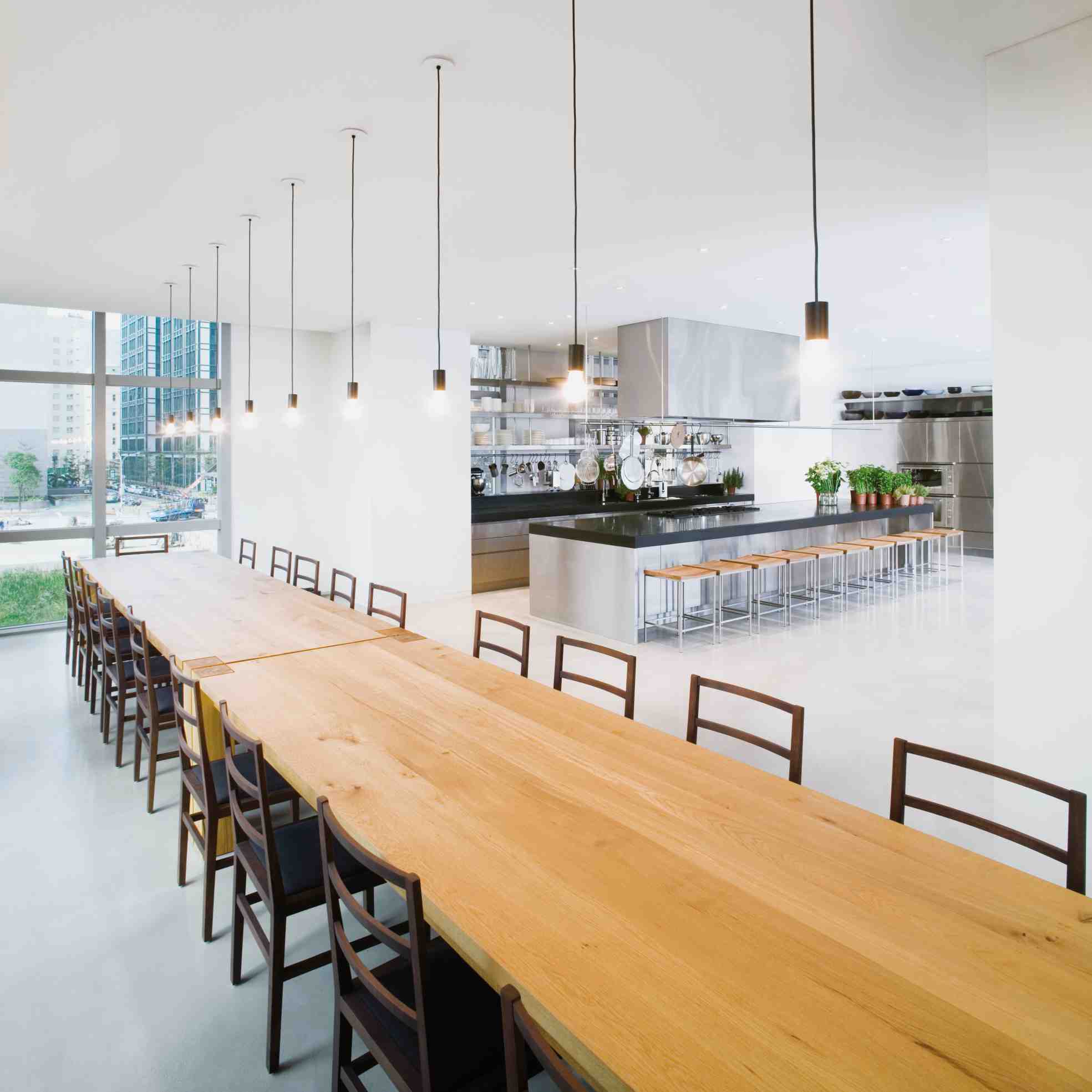 Langer, heller Konferenzraum mit e15 Bigfoot Tisch aus Massivholz und Stühlen.