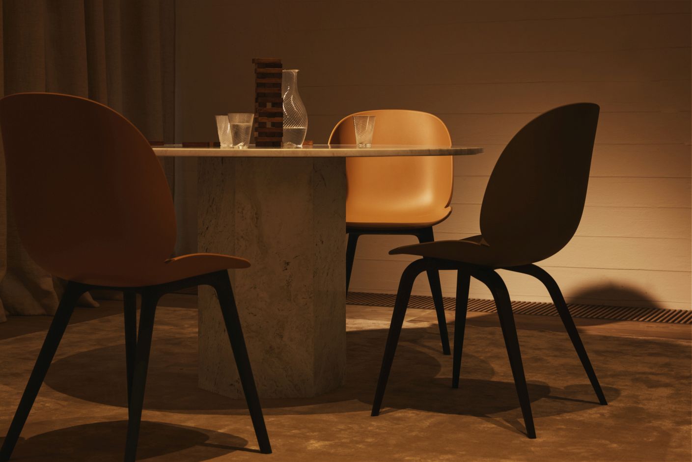 Beetle Chair Esszimmerstuhl in Alabaster White von Gubi, ungepolstert mit schwarzem Gestell, an Esstisch.