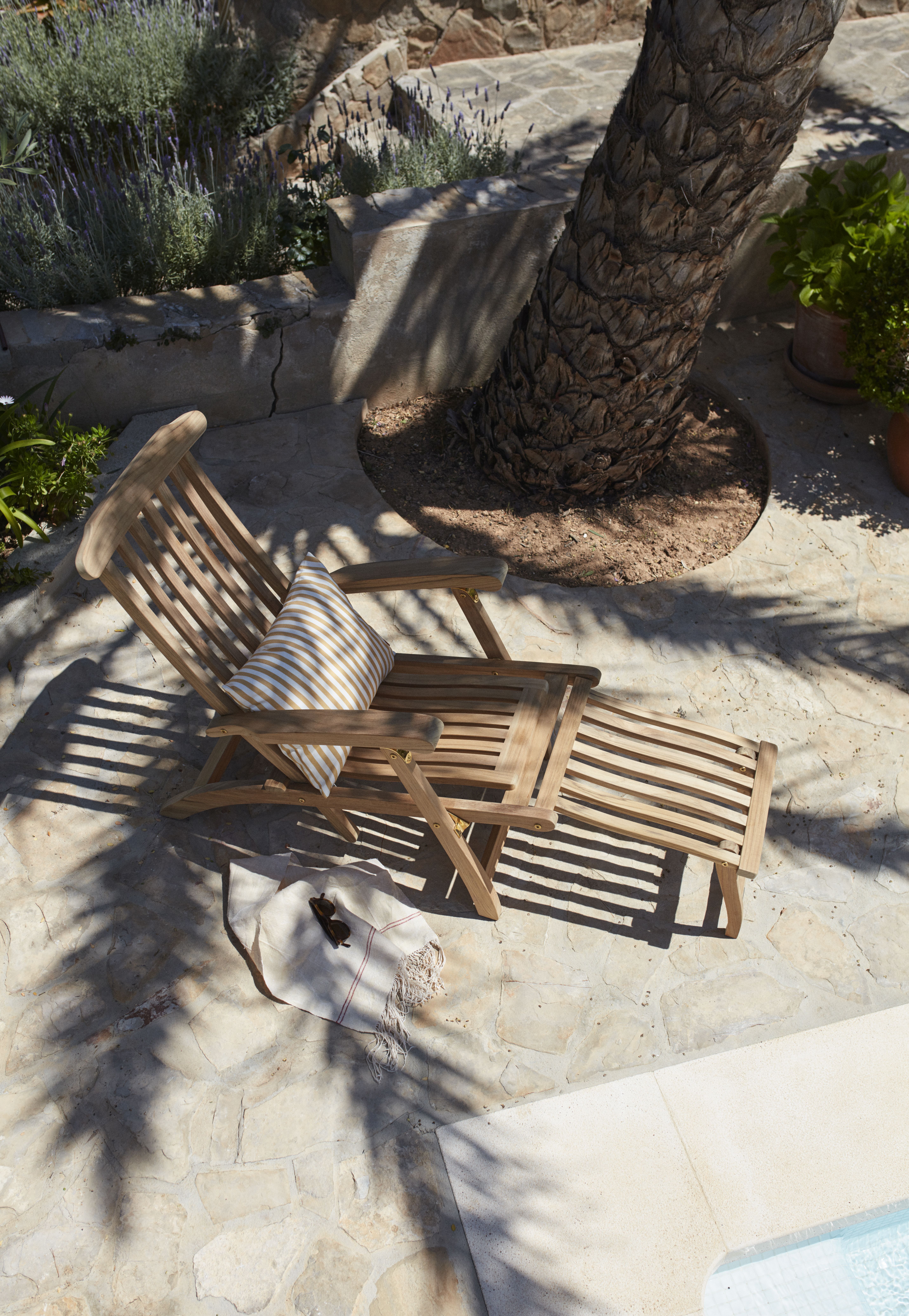 Steamer Deck Chair Liegestuhl aus Teakholz im Garten mit Kissen und Handtuch.