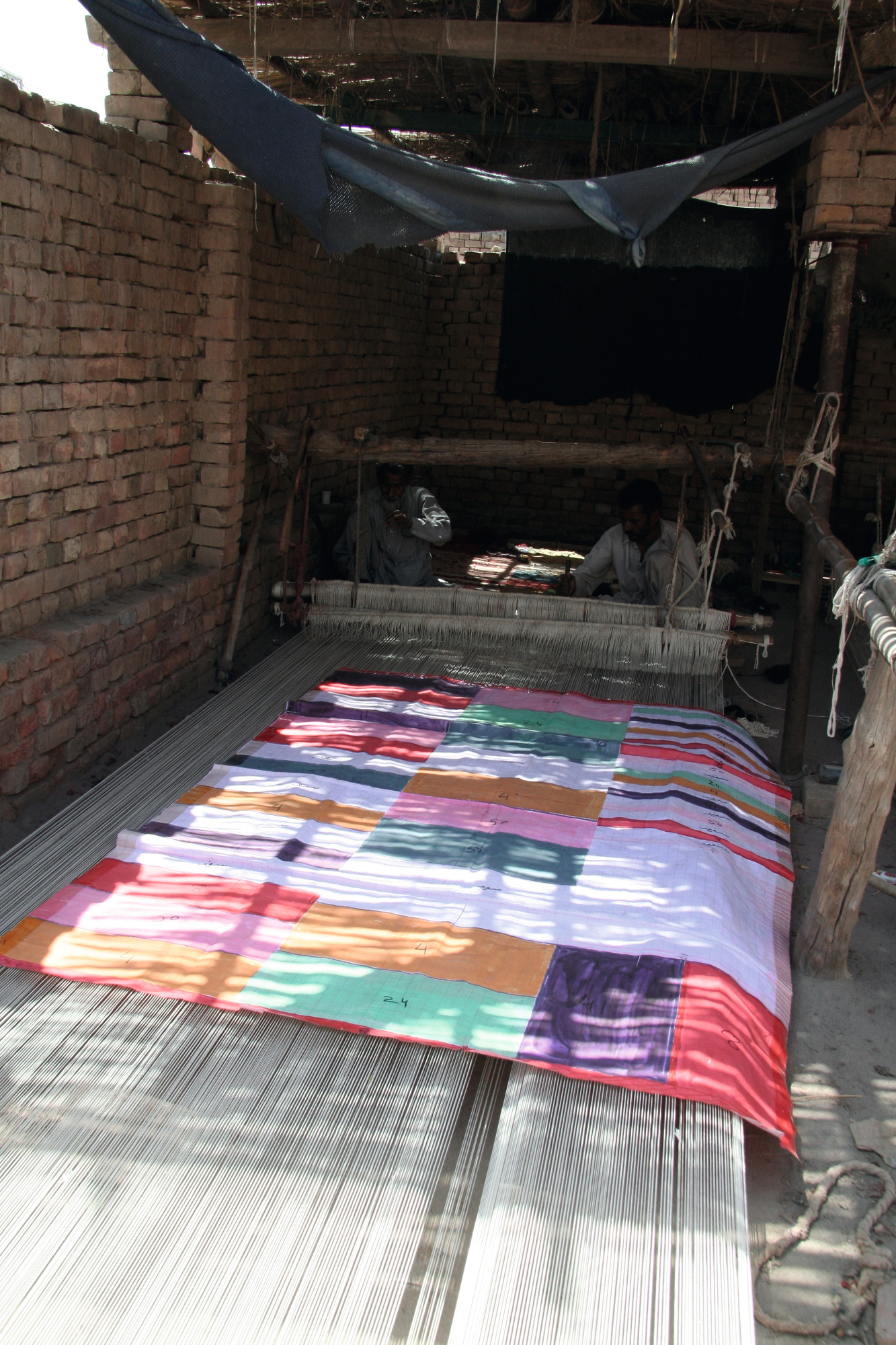 Medina Teppich von Nanimarquina in der Herstellung: Handgeknüpfter Wollteppich auf einem Webstuhl.