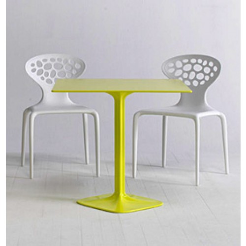 Zwei weiße Supernatural Sedia Stühle mit Löchern und ein gelber Tisch. Modernes Möbeldesign.