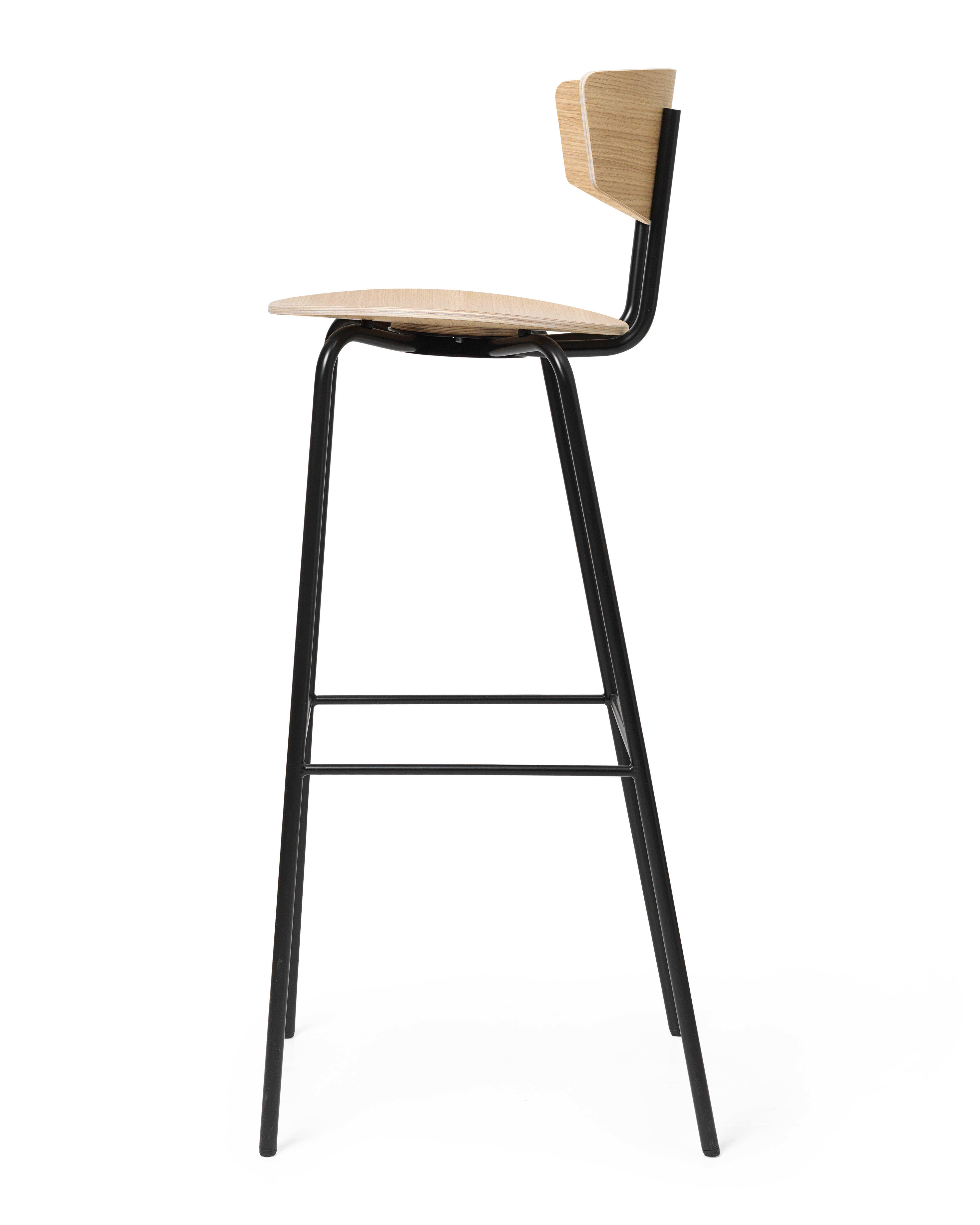 Herman Barstuhl von Ferm Living, Seitenansicht: Holz-Sitzfläche und Rückenlehne, schwarzes Metallgestell. Moderner Barhocker.