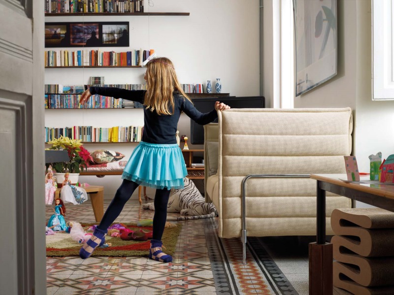 Wohnzimmer mit Gueridon Bas Tisch von Vitra, Kind tanzt im Vordergrund. Designmöbel für Kinderzimmer.