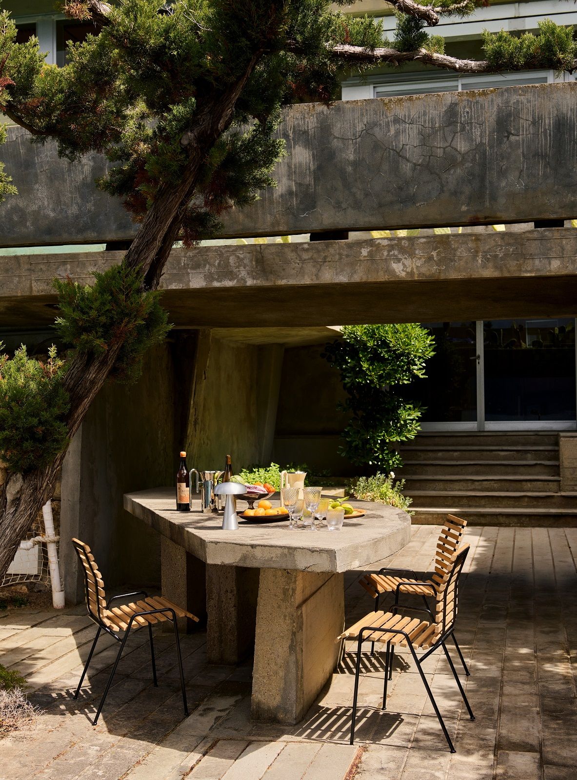 RFH Robin Day Stühle von AndTradition im Garten, mit Esstisch und Speisen.