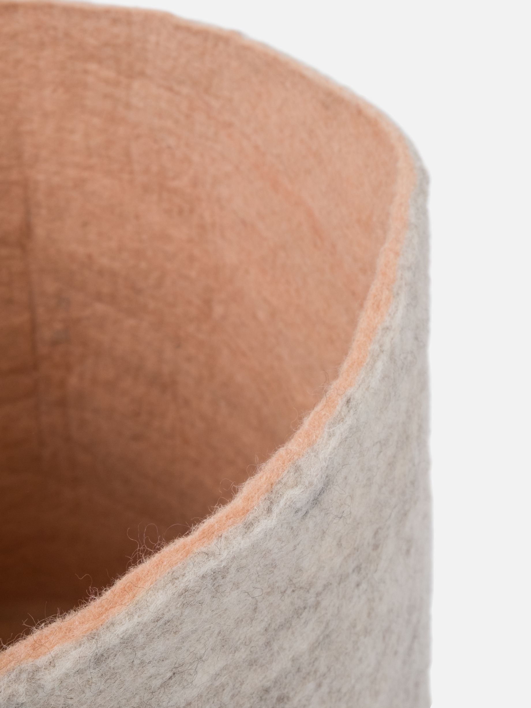Detailaufnahme des Filzkorbs Béla von myfelt, grau meliert mit apricotfarbenem Innenfutter.