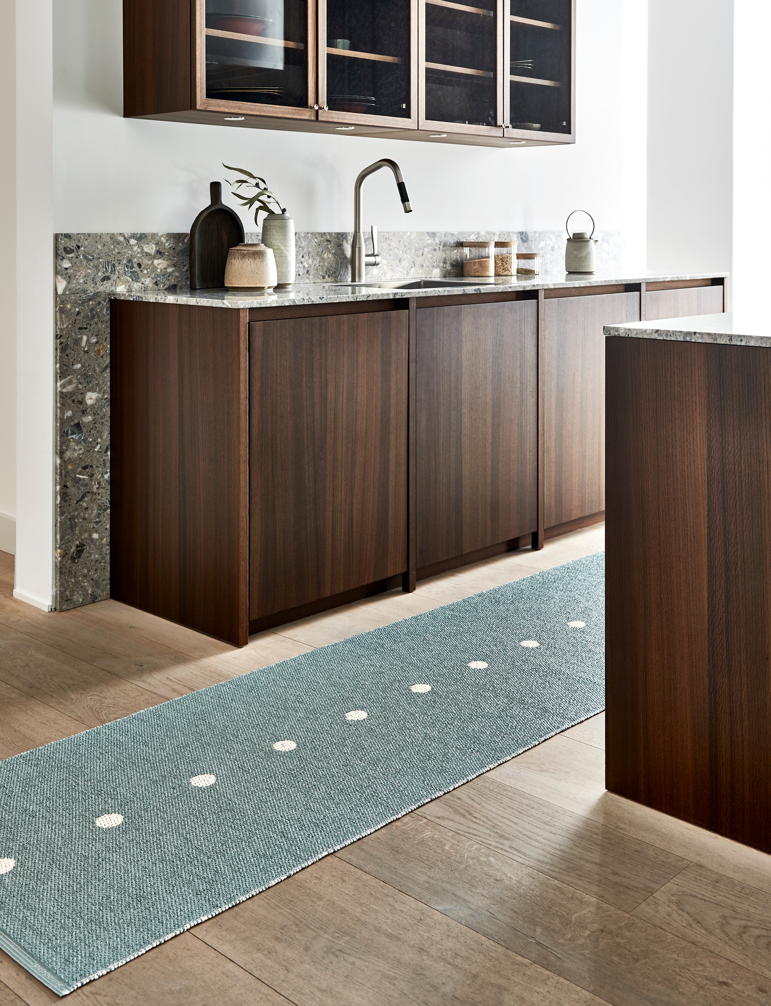 Blauer Pappelina Kunststoffteppich "Peg" (70x280 cm) mit weißen Punkten in moderner Küche auf Holzboden.