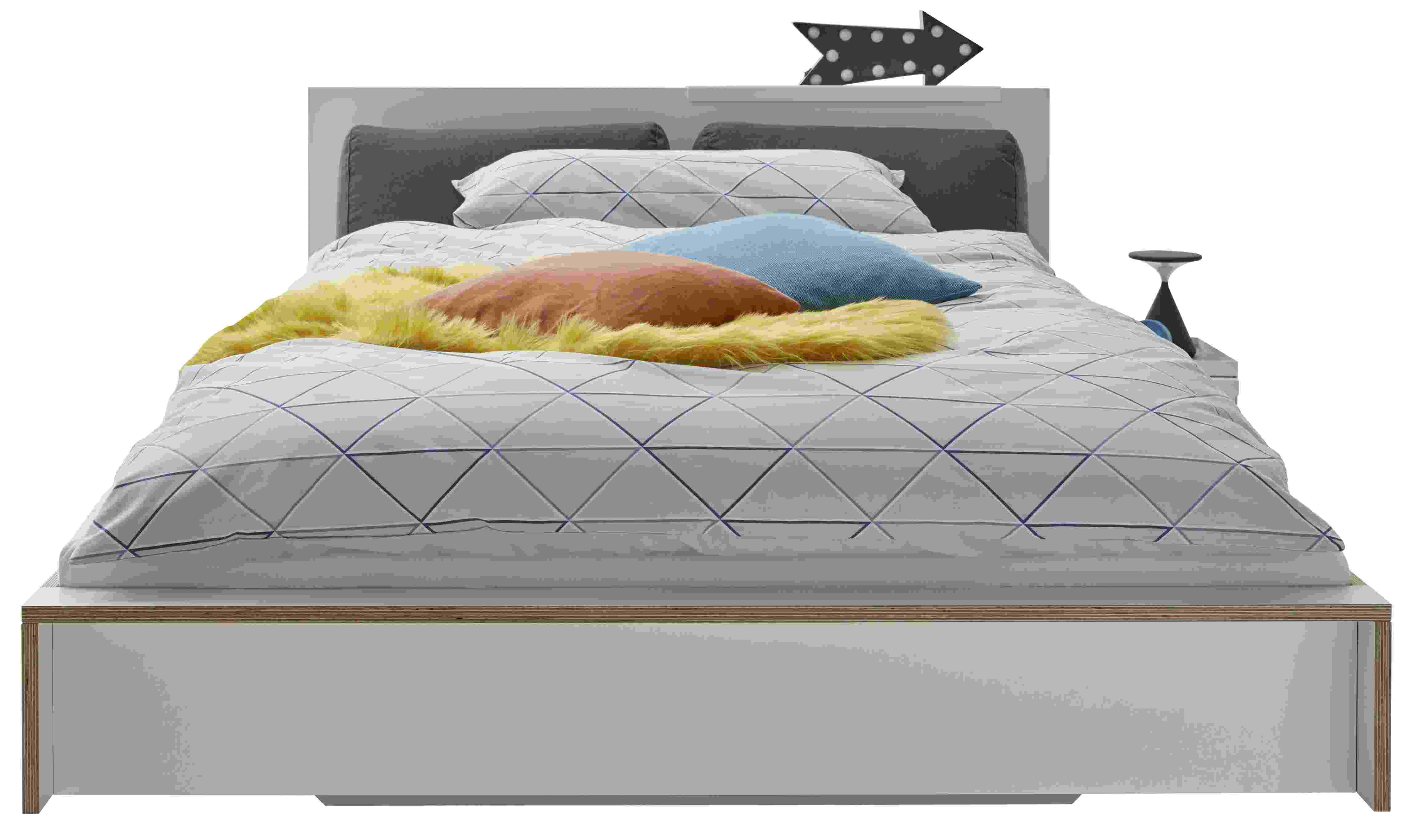 Anthrazitfarbenes Flai Bett Kopfteil von Müller Möbelwerkstätten mit Kissen und Bettwäsche.