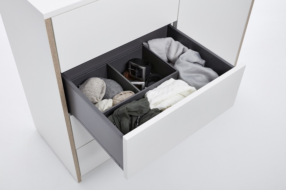 Geöffnete Schublade der Modular Plus Kommode von Müller Möbelwerkstätten mit Fächern und Kleidung.