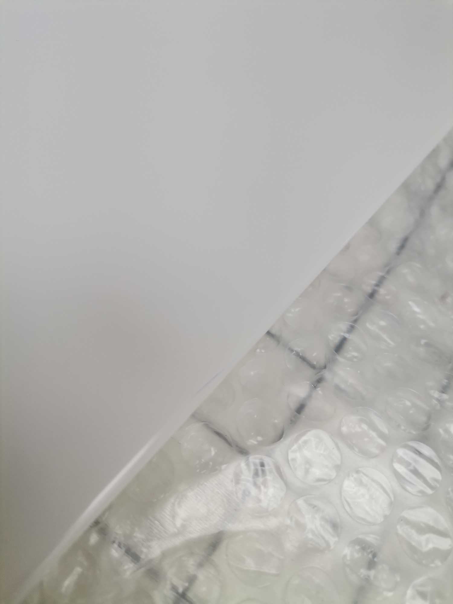 Nahaufnahme von USM Haller Ersatzteilen (Mängelexemplar) verpackt in Luftpolsterfolie, bereit für den Versand.