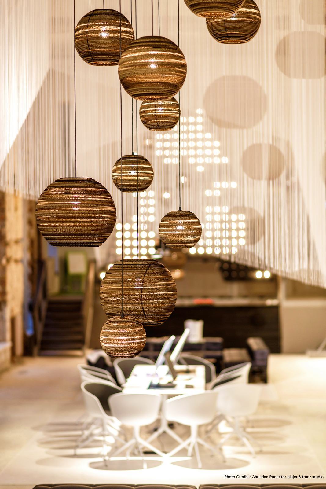 Mehrere Moon10 Scraplights Hängeleuchten von Graypants aus recycelter Pappe in einem Raum.