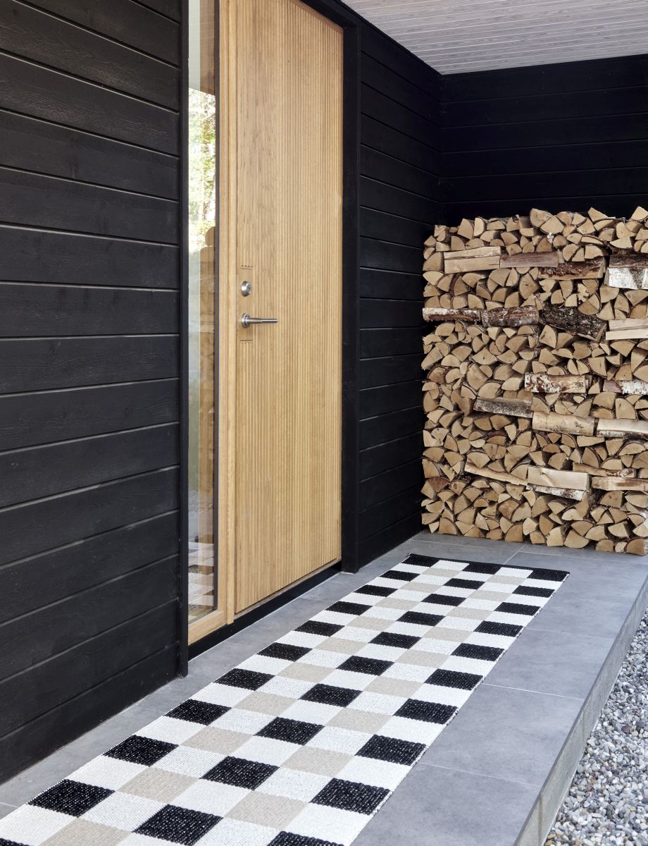 Pix Teppich von Pappelina, 70x160cm, Army-Farbe, mit Schachbrettmuster vor einer Haustür.