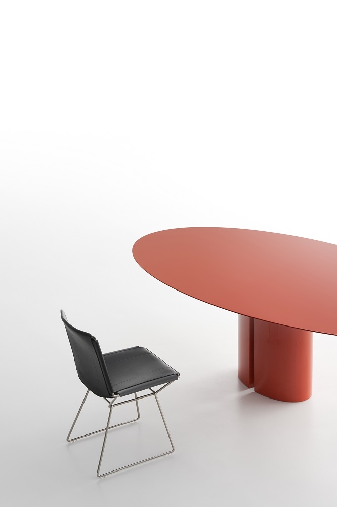 NVL Table von MDF Italia: Roter, ovaler Esstisch mit zylindrischem Fuß und schwarzem Stuhl.