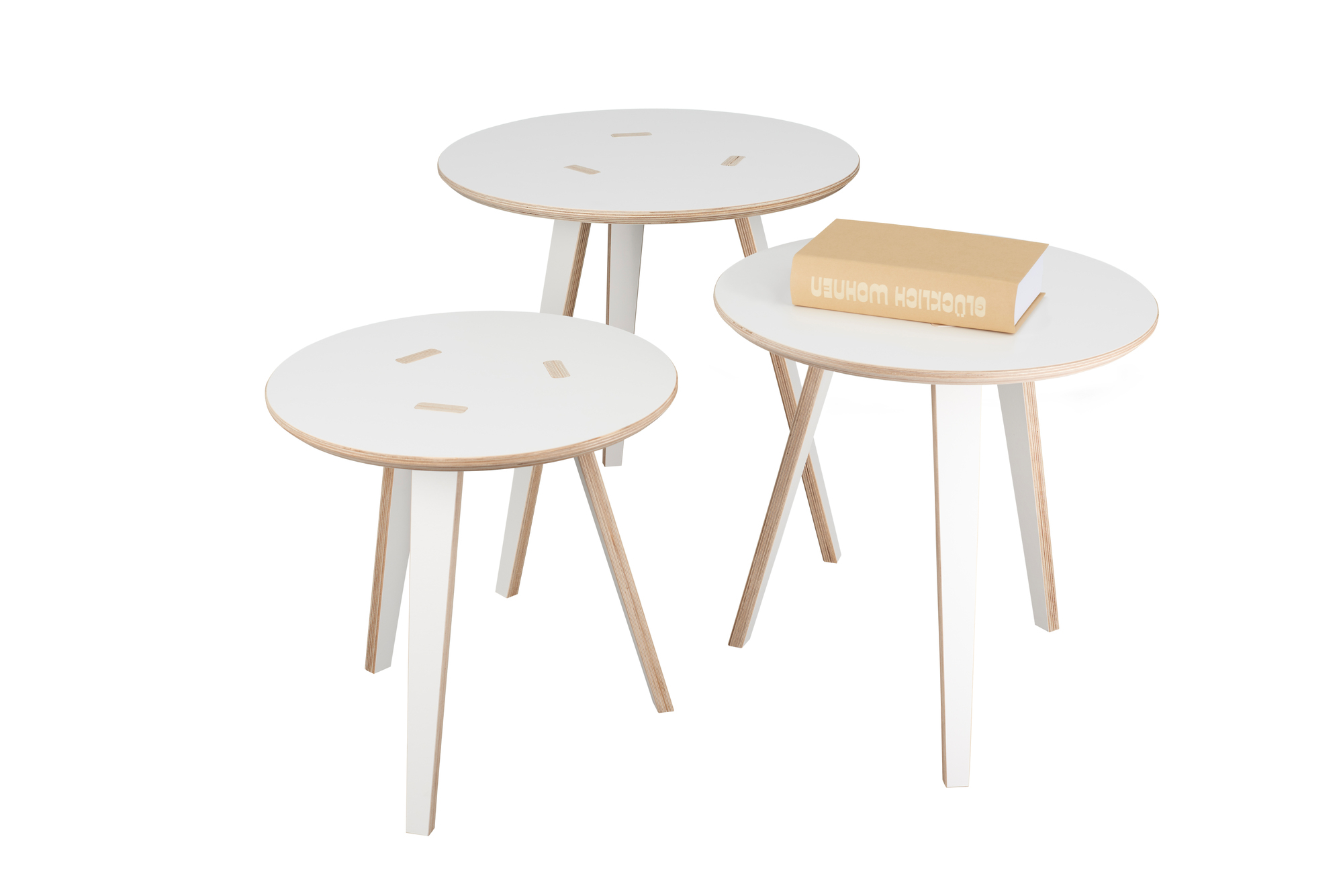 Drei weiße Tojo Tische, runde Beistelltische aus Holz, einer mit Buch, modernes Möbeldesign.