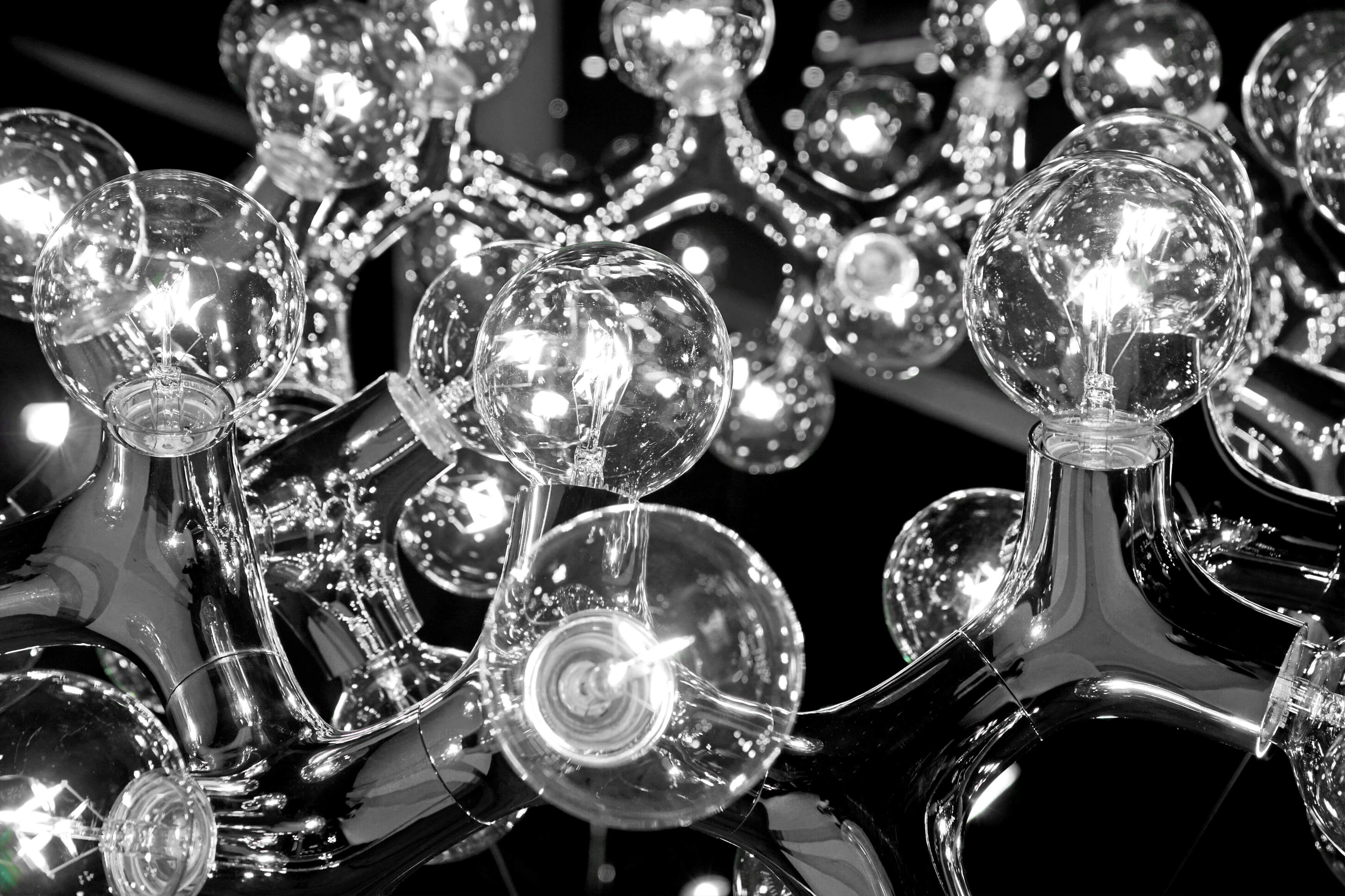 Schwarz-Weiß-Foto der DNA Pendelleuchte mit klaren Glühbirnen und Chrom-Finish. Moderne Deckenleuchte für stilvolle Innenräume.