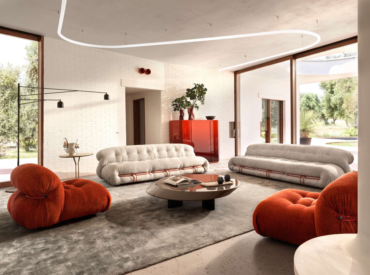 Helles Wohnzimmer mit Cassina Soriana Sofa und Sessel in Beige und Orange. Modernes Design.
