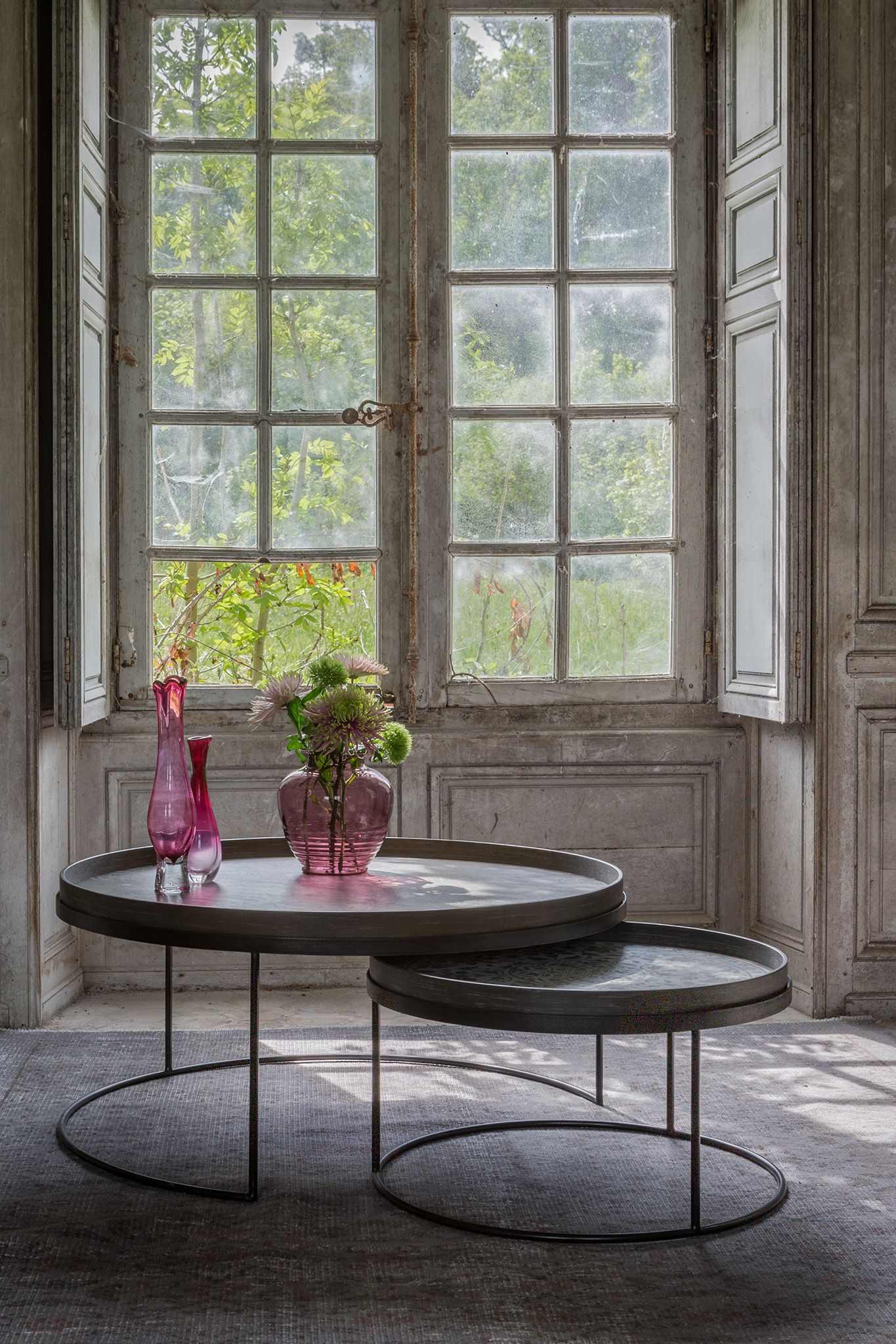 Couchtisch 2er Set, schwarz, rund, von Ethnicraft. Moderne Wohnzimmermöbel mit Vasen dekoriert.