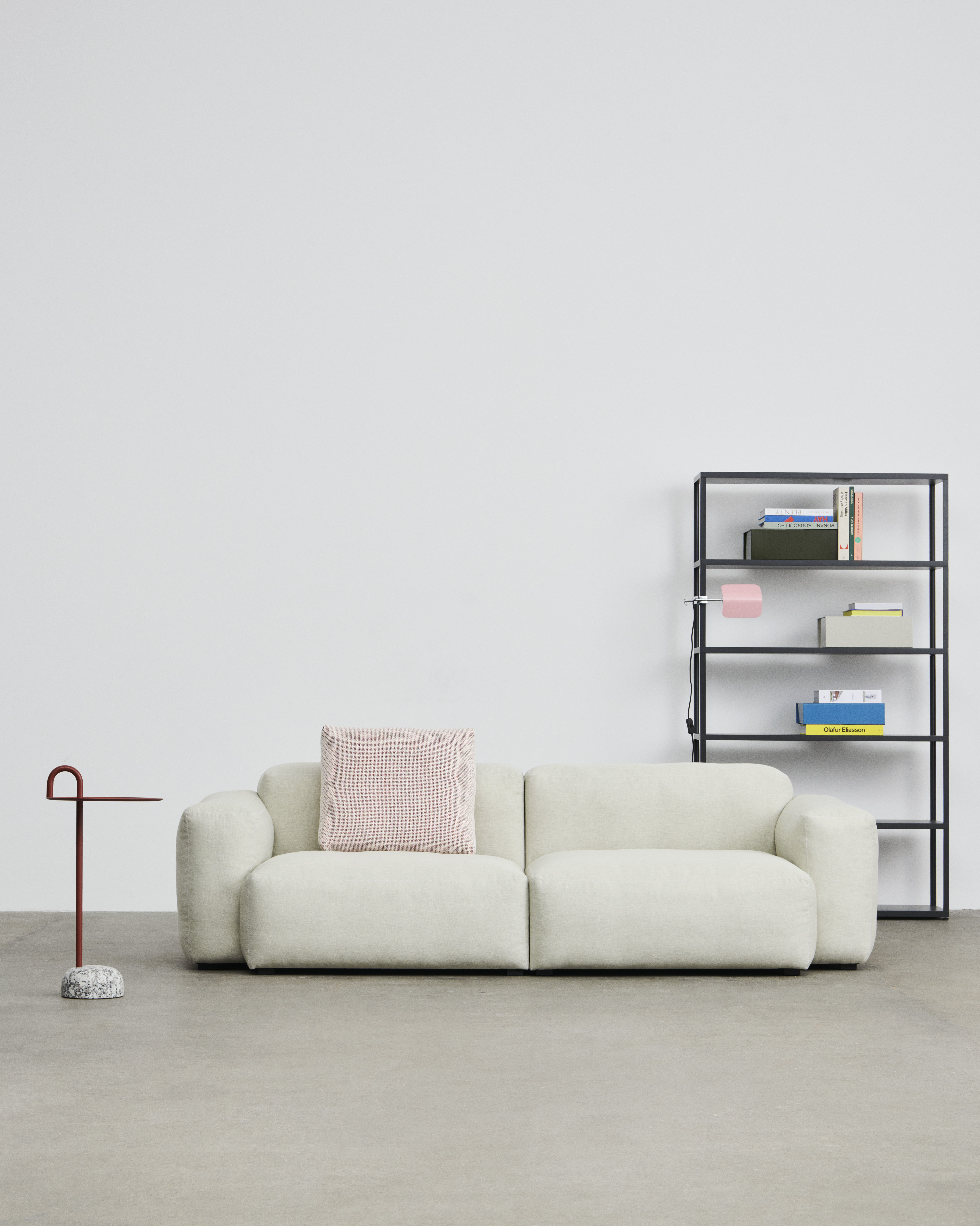 Helles Wohnzimmer mit Hay New Order Regal, Sofa mit Kissen und Beistelltisch.