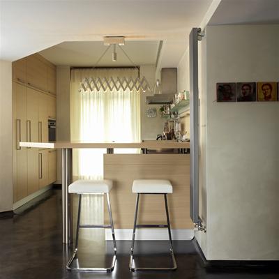 Zwei weiße Barhocker von Knoll International vor einer Küchenbar. Designermöbel für moderne Küchen.